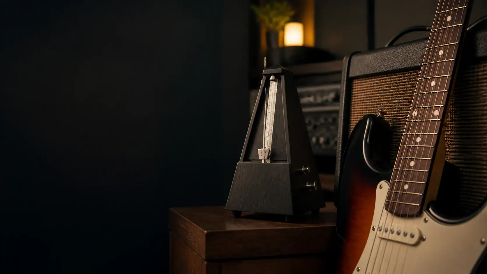 Mit Metronom üben: mechanisches Metronom neben einer E-Gitarre im Studio